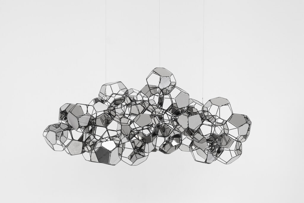 El trabajo de Saraceno se despliega en el cruce entre arte, arquitectura, ciencia, técnología y activismo. Sus propuestas buscan aportar conocimientos y experiencias colectivas para enfrentar algunas de las problemáticas más urgentes del presente. Sus proyectos llaman la atención sobre la necesidad de renovar estilos de vida e indagan sobre formas alternativas y sustentables de transporte, comunicación y habitabilidad. En ocasiones, despliega su obra fuera de los circuitos artísticos y tiene lugar en el espacio aéreo o en paisajes, como desiertos o salares, en diálogo con las comunidades locales. Sus exhibiciones suelen acercar a museos y galería propuestas radicales que modifican los usos tradicionales del espacio, involucrando al público en experiencias corporales desafiantes y de cooperación. Las obras también integran fenómenos fuera del rango de lo visible, como las vibraciones que producen cuerpos y materiales, o tienen como parte y destinatarixs a habitantes no-humanxs del lugar, como las arañas. En ese sentido, en cada proyecto, el artista trama un sistema orgánico de relaciones entre público y entorno para abrir canales de comunicación y sociabilidad que cruzan las fronteras entre sentidos y especies. Saraceno es un observador planetario que encuentra referencias formales y estéticas en fenómenos tan amplios como los ritmos de las corrientes de aire y las redes ecosistémicas que hacen a la atmósfera y la biosfera, integrándolos en su producción de manera plástica, escultórica, instalativa y también fotográfica. Trabaja junto con un enorme equipo de colaboradorxs para desarrollar investigaciones en conjunto desde distintos saberes, especialistas e instituciones científicas. Unión de utopía y posibilidad, la práctica artística de Saraceno expande los límites del arte contemporáneo al servicio de nuevos horizontes. De lo microscópico a lo cósmico, en esa intersección, sus intereses abarcan diversas áreas de estudio y acción que se entrelazan para diseñar e impulsar proyectos de transformación social y ambiental.